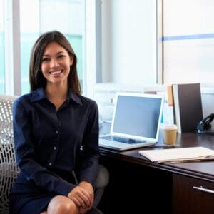 A woman sitting at her desk with a laptop.