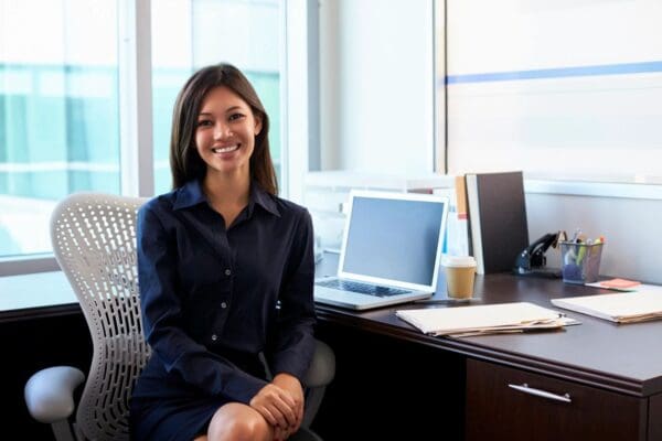 A woman sitting at her desk with a laptop.